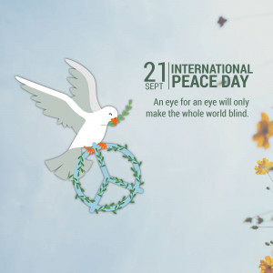 A white dove carrying an olive branch flying over a peace symbol wreath.