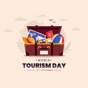 An open suitcase filled with travel items and a World Tourism Day banner.