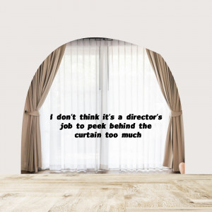 A stage curtain with a quote about directors and curiosity.
