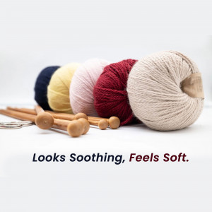 A collection of colorful yarn balls and wooden knitting needles on a white surface.