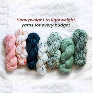 Assortment of colorful yarn skeins on a white fabric background