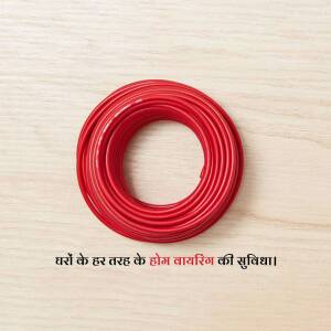 A coil of bright red electrical wire on a light wood surface.
