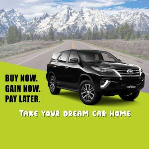 Black Toyota Fortuner parked on a road with mountains in the background, advertising a 'Buy Now, Pay Later' offer.