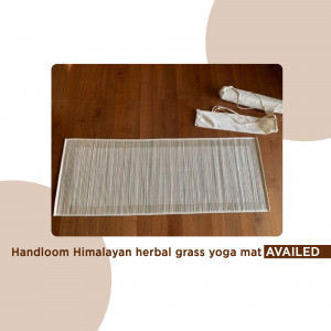 Close-up of a handloom Himalayan herbal grass yoga mat on a wooden floor.