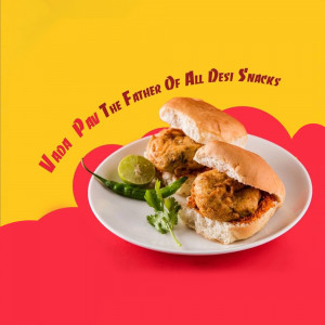 Close-up of Vada Pav, a popular Indian street food, served with green chili and lemon wedge.