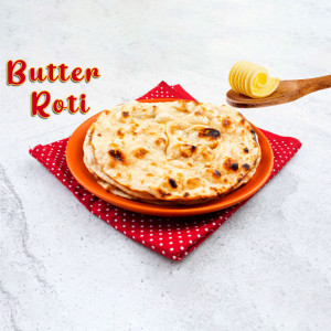 Stack of Butter Roti with a dollop of butter on a wooden spoon