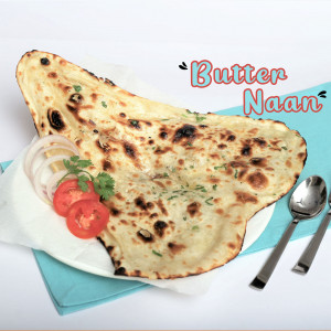 Close-up of Butter Naan with tomato and onion garnish