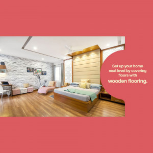 A spacious bedroom with wooden flooring, a large bed, and a lounge area.