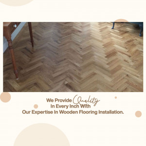 Close-up of herringbone patterned wooden flooring with text overlay promoting flooring installation services.