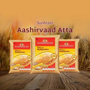 Three packs of Aashirvaad Multigrains Atta displayed against a wheat field background.