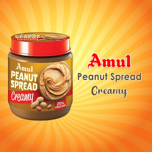 Jar of Amul Creamy Peanut Spread with peanuts and a burst of orange light.