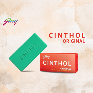 Two Cinthol Original soap bars, one green and one red, against a peach background.