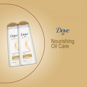 Two bottles of Dove Nourishing Oil Care shampoo against a beige background.