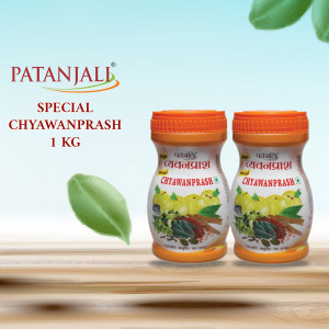 Two bottles of Patanjali Special Chyawanprash 1 KG with green leaves on a wooden surface.