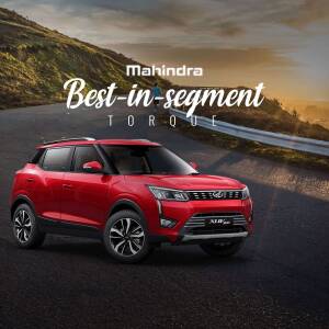 Red Mahindra XUV300 car on a winding road