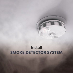 Close-up of a smoke detector installed on a ceiling with smoke effect and text 'Install Smoke Detector System'