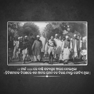Black and white photograph of Mahatma Gandhi leading the Dandi March with followers.