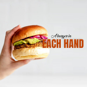 A hand holding a vegan burger with avocado and pickled onions.