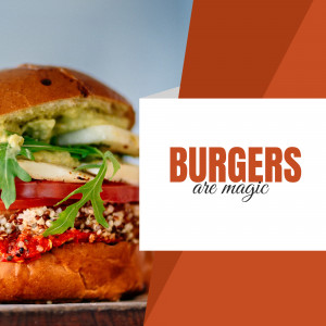 Close-up of a stacked gourmet burger with fresh ingredients and a vibrant orange background.