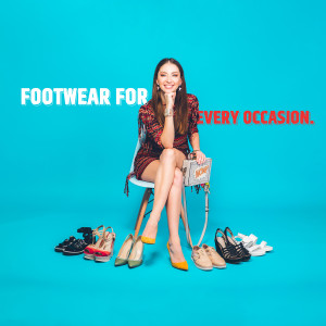 Woman surrounded by various shoes, promoting a footwear collection.