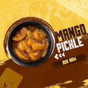 Close-up of homemade mango pickle in a black bowl with mango slices in the background.