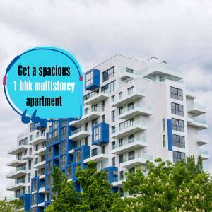Exterior view of a modern, multi-story apartment building with a blue accent and green trees.