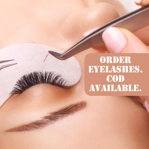 Close-up of a professional applying individual false eyelashes with tweezers.