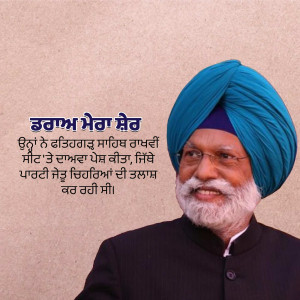 A smiling Sikh man wearing a blue turban and black suit.