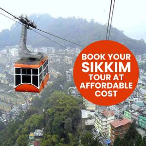 Orange cable car ascending over a hilly town with a promotional circle for Sikkim tours.