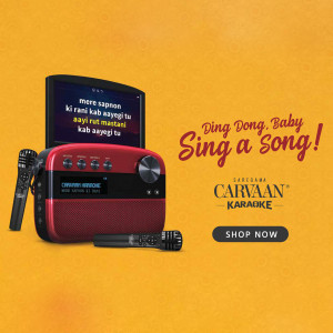Carvaan Karaoke device with microphones and song lyrics displayed on the screen.