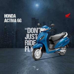 Blue Honda Activa 6G scooter against a blurred city background with the tagline 'Don't Just Ride, Fly'.