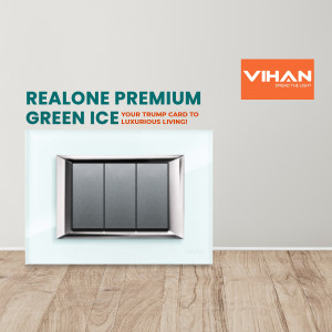 Close-up of a Vihan Realone Premium Green Ice light switch on a white wall with wooden flooring.