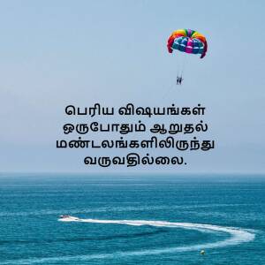A colorful parasail with two people soaring over a blue ocean with text in Tamil.