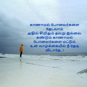 A person in an orange jacket standing on a beach looking out at a stormy sea with Tamil text overlayed.