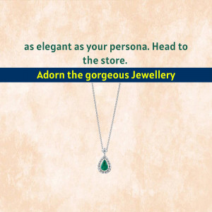 Close-up of a silver necklace with a green emerald pendant.