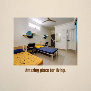 A well-lit shared bedroom with two single beds, desks, and a ceiling fan.