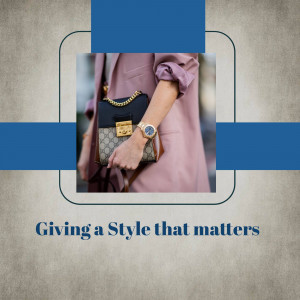 A woman's hand holding a designer handbag and wearing a watch, with a pastel pink suit.