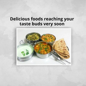 A selection of Indian dishes in stainless steel bowls with roti.