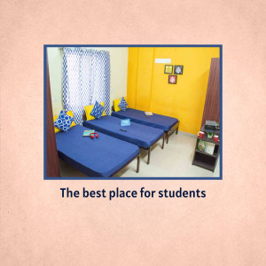 Three single beds in a student room with blue bedding and yellow walls.