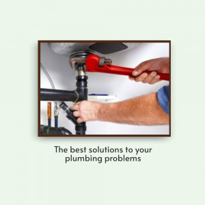 Close-up of a plumber using a wrench on pipes under a sink.