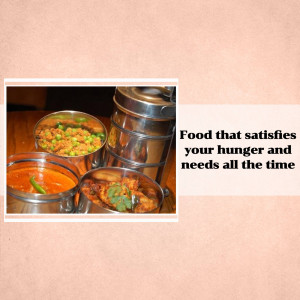 A close-up of a traditional Indian tiffin carrier with various curries and rice.