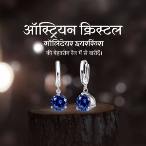 Close-up of silver earrings with blue Austrian crystal stones on a wooden surface.