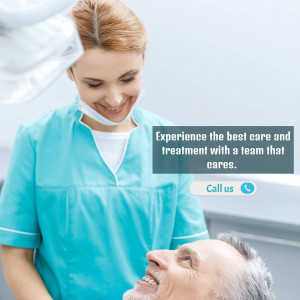 Dentist examining a male patient with a reassuring smile.