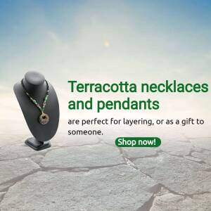 Terracotta necklace on a black bust against a cracked earth background with a shop now button.