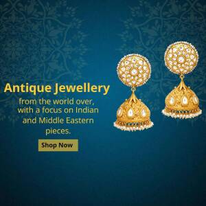 Close-up of ornate gold earrings with pearls, showcasing antique Indian jewellery.