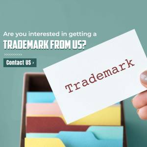 Hand holding a business card with the word 'Trademark' on it, with colorful folders in the background.