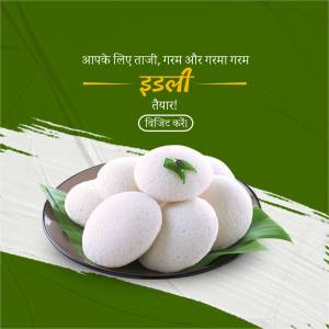A plate of steaming hot Idli with a green banana leaf garnish.