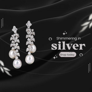 Close-up of silver and pearl drop earrings on a dark background