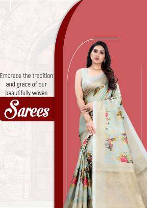 Woman wearing a light blue floral print saree with a red border.