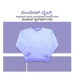 A gray v-neck sweater laid flat on a lavender and white striped background.
